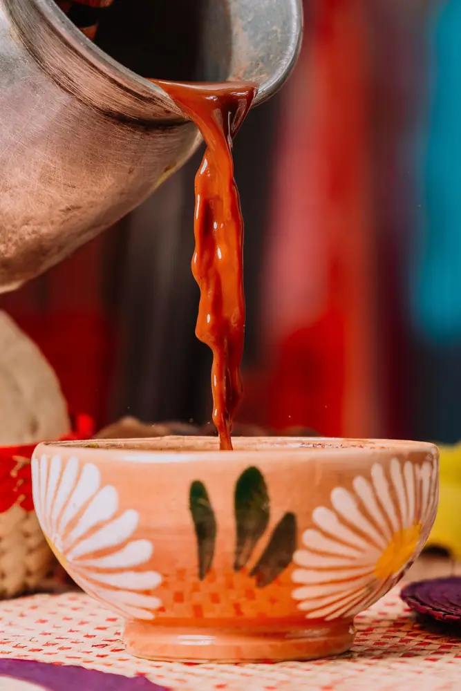 Chocolate caliente servido en un tazón de barro pintado con margaritas